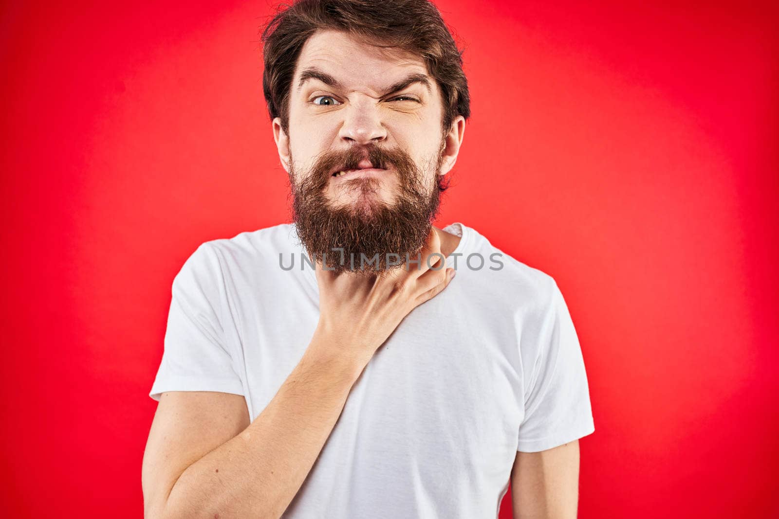 man in t-shirt gesturing with his hands dissatisfaction studio red uniform. High quality photo