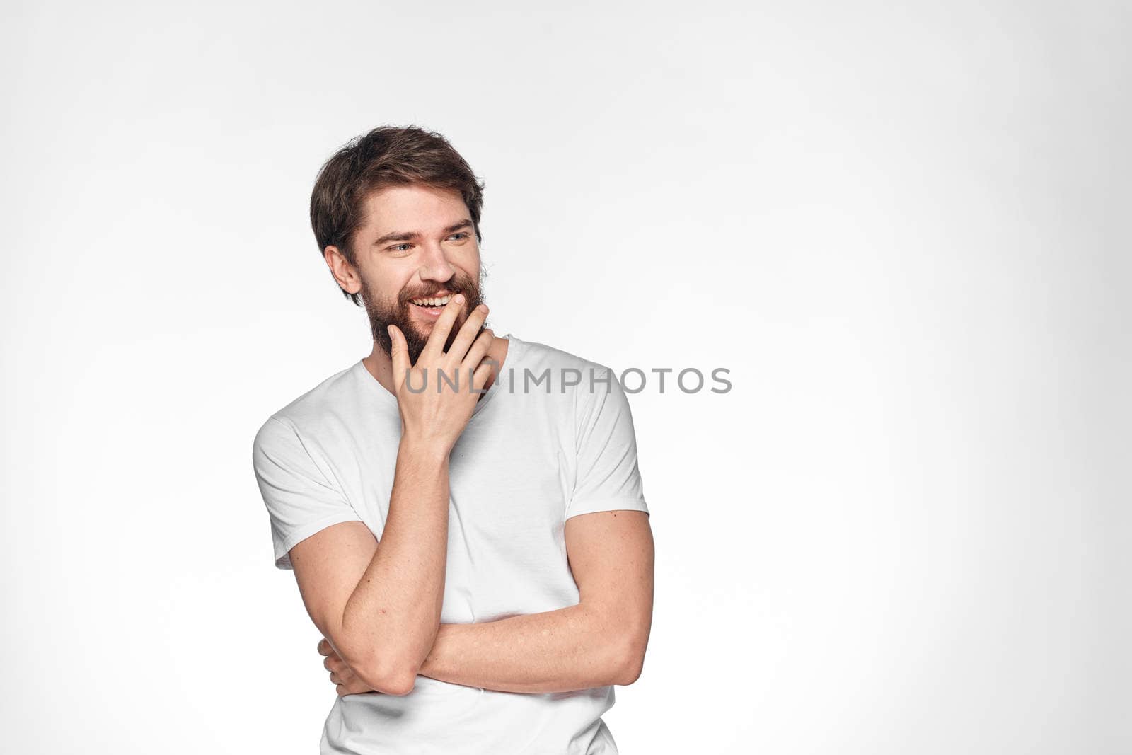 Bearded man in white t-shirt gesture with hands emotions light background by SHOTPRIME