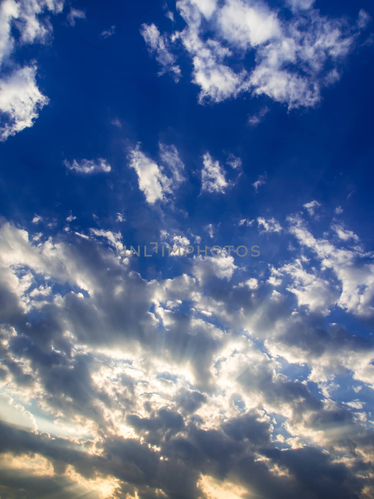 White and grey fluffy clouds in the blue sky with morning light from the sunrise