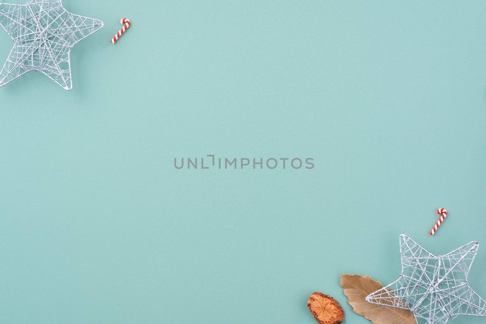 Top view of Christmas holiday decoration ornament composition with Christmas tree, gift star, gingerbread man flat lay with copy space isolated on green background.