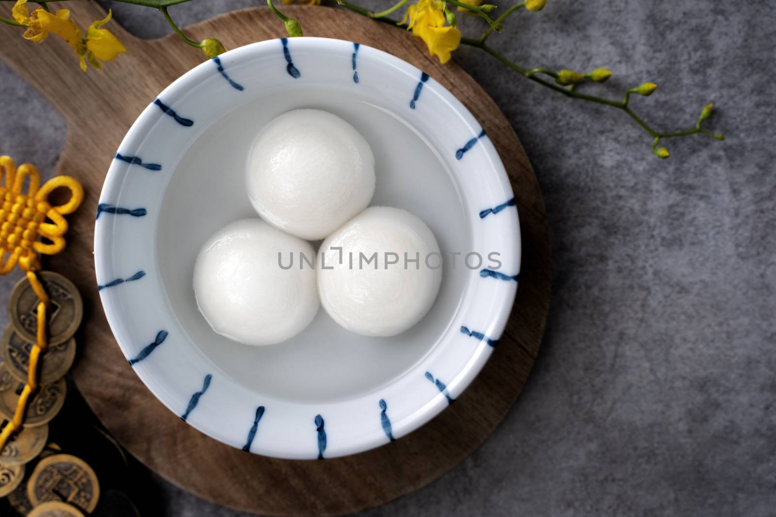 Top view of big tangyuan yuanxiao (yuan xiao tang yuan, glutinous rice dumpling balls) in a bowl on gray background for lunar new year festival food with copy space.