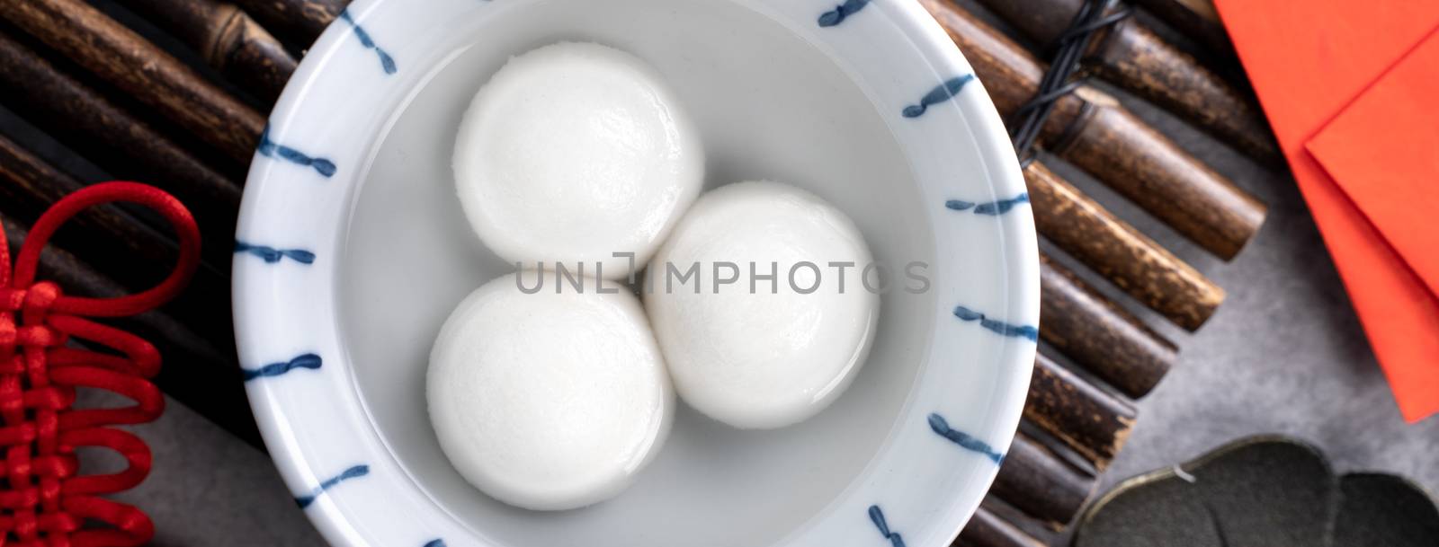 Top view of big tangyuan yuanxiao (yuan xiao tang yuan, glutinous rice dumpling balls) in a bowl on gray background for lunar new year festival food with copy space.