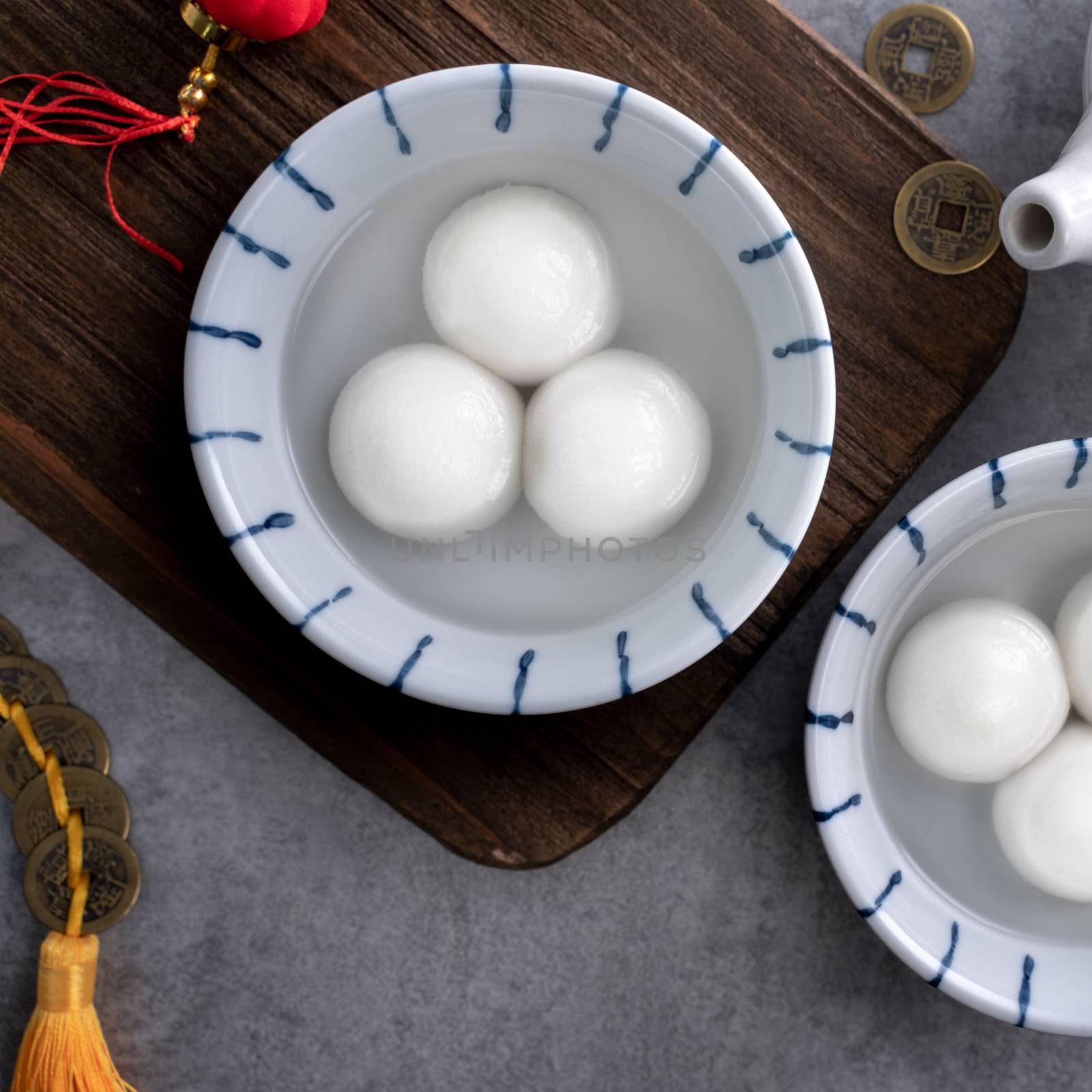 Top view of big tangyuan yuanxiao (yuan xiao tang yuan, glutinous rice dumpling balls) in a bowl on gray background for lunar new year festival food with copy space.