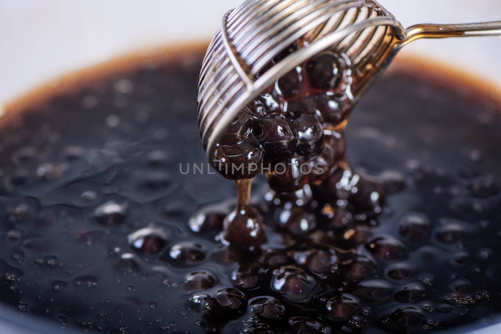 Cooking, boiling brown sugar flavored tapioca pearl balls, ingredient of bubble tea, preparing food and drink, close up, recipe cookbook steps design concept.