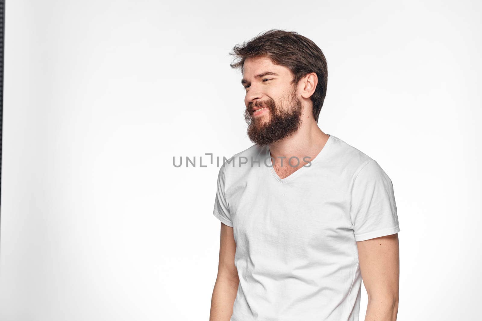 cheerful emotional bearded man gesturing with his hands close-up light background. High quality photo