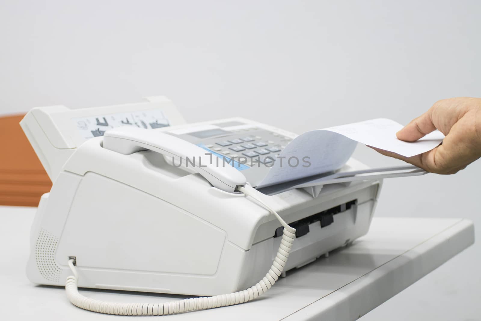 hand man are using a fax machine in the office, equipment for data transmission.