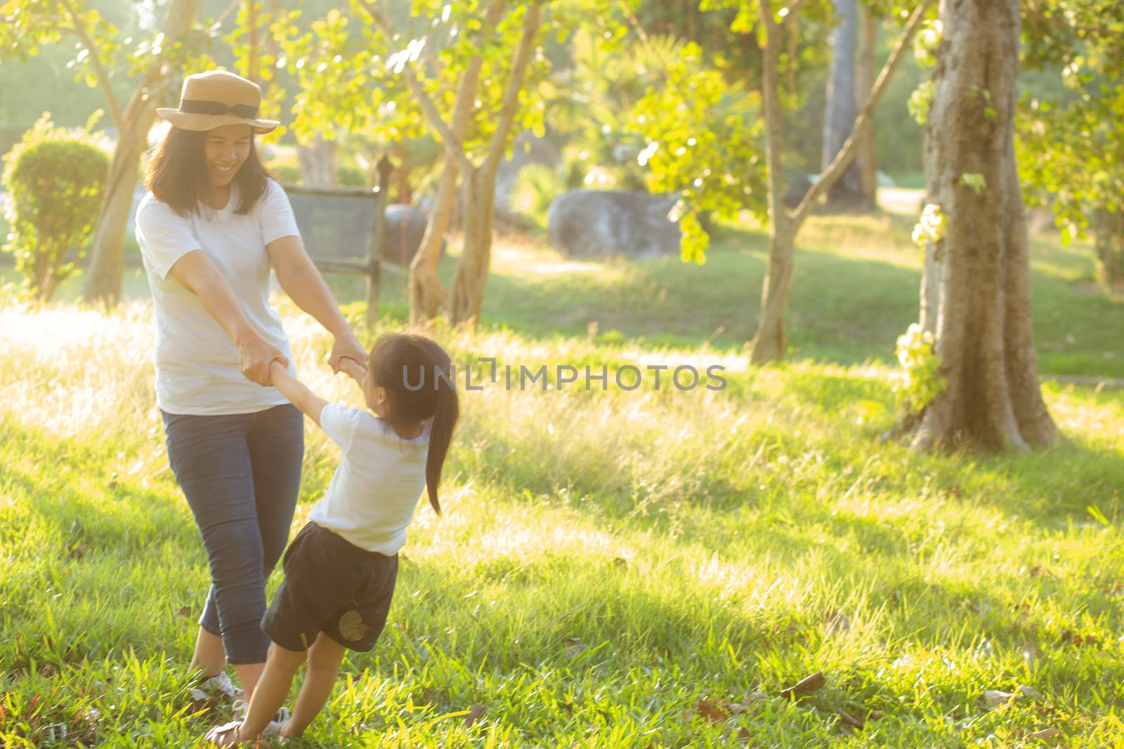 Young asian mother and little daughter playing the park with fun and happiness, family enjoy and relax and leisure together, mom and children smiling laughing in summer day.