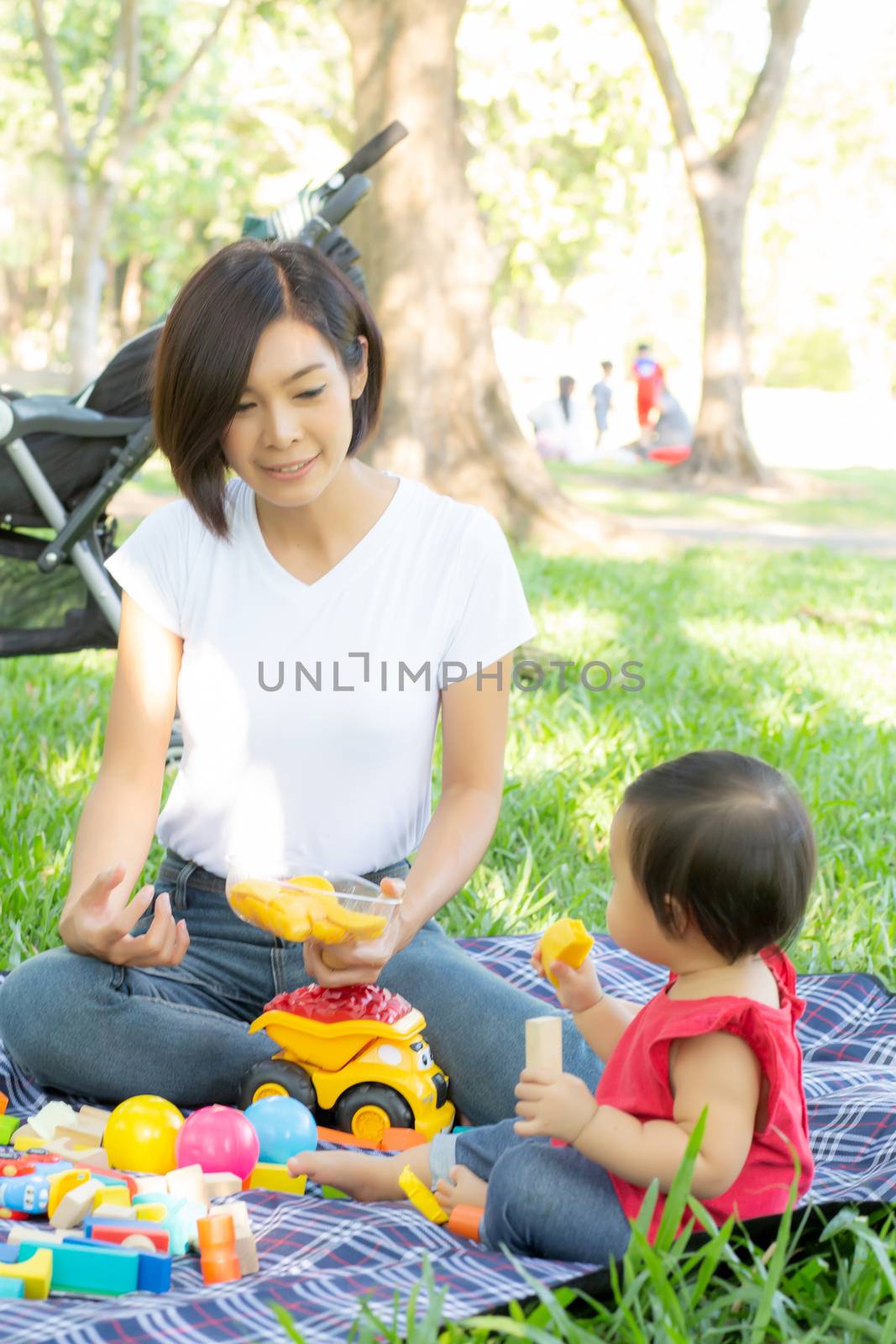 Beautiful young asian mom and daughter playing toy blocks for le by nnudoo