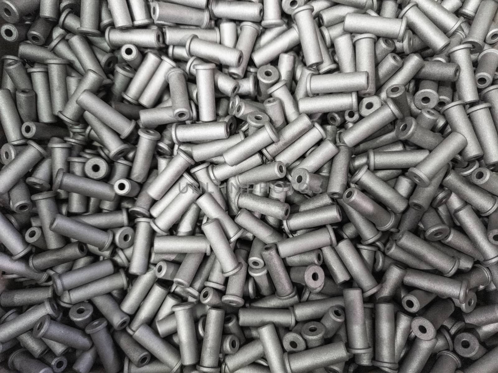 a pile of small sand blasted steel parts - close-up with selective focus and blur.