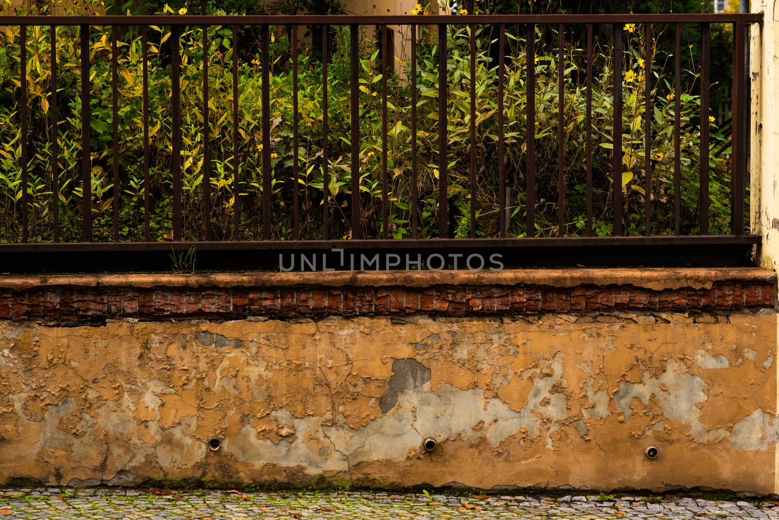 Rotten fence surrounding a house in the city by gonzalobell