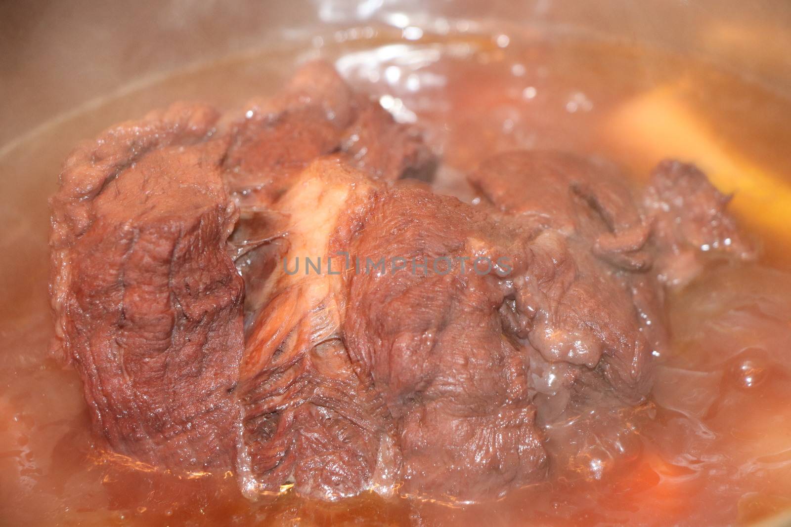 whole piece of beef is boiling in the pot