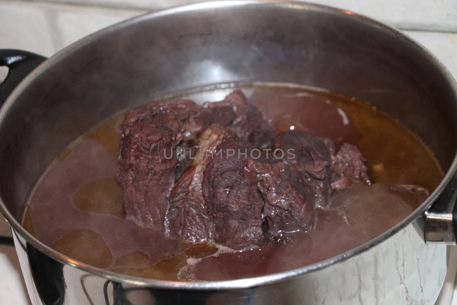 whole piece of beef is boiling in the pot