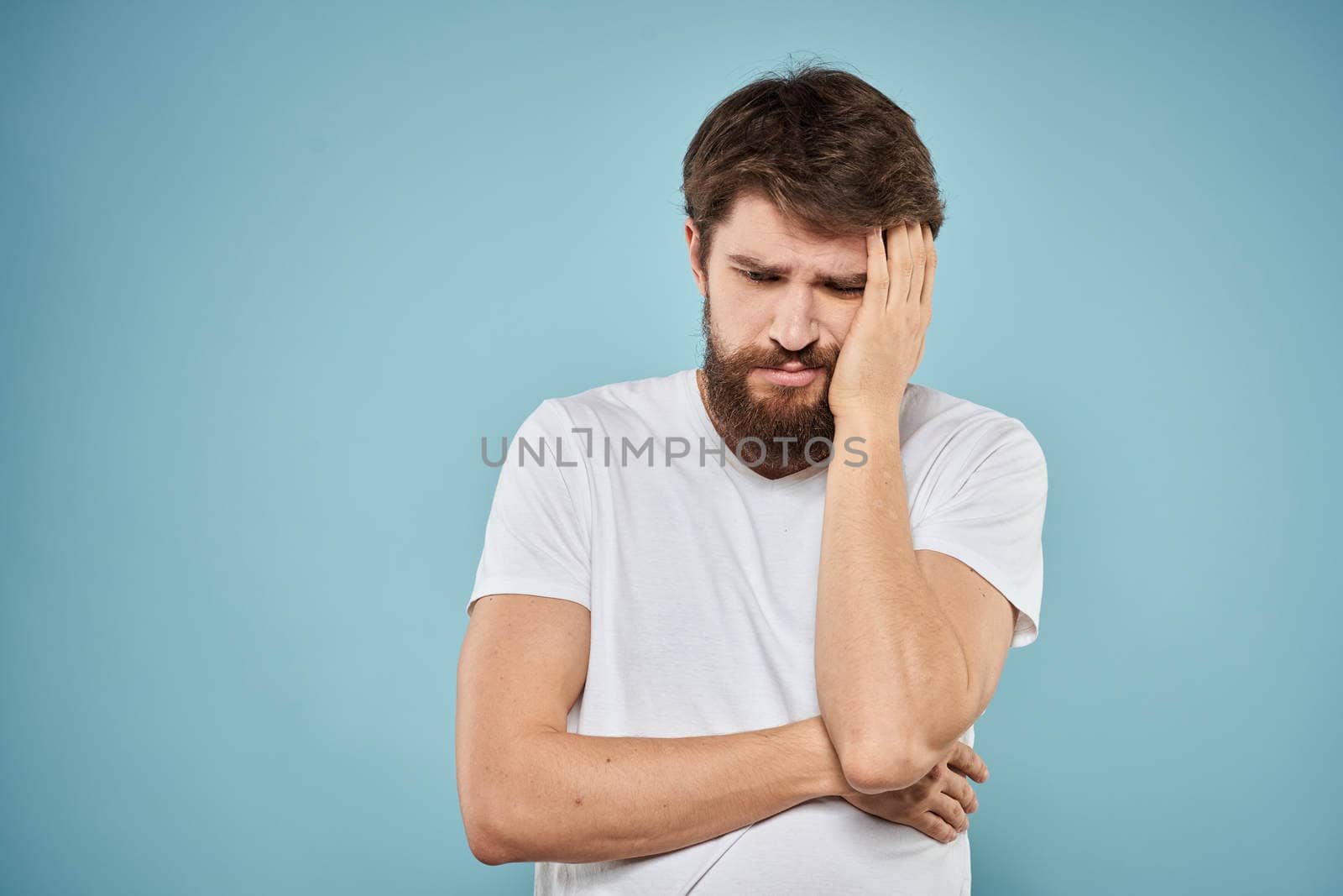 Man in white t-shirt emotions facial expression cropped view studio blue background lifestyle by SHOTPRIME