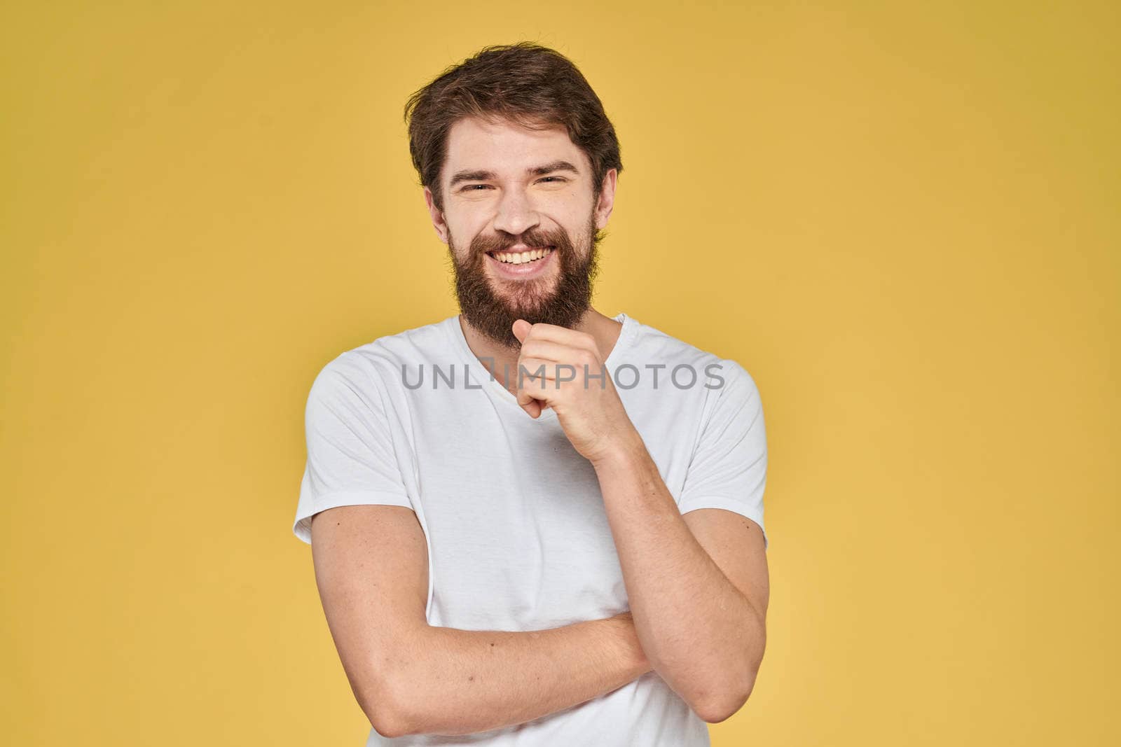 Bearded man on emotions white t-shirt fun lifestyle yellow background. High quality photo