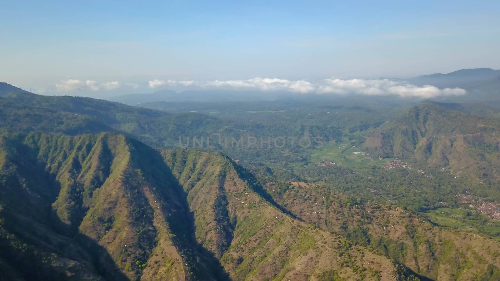 a drone aerial view of a countryside of bali. Aerial view of the mountains above the village of Amed, Indonesia by Sanatana2008