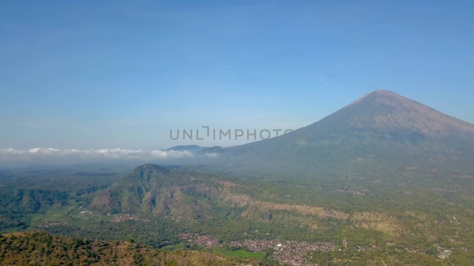 The volcano Gunung Agung dominating the horizon taken from Amed against a clear blue sky, a little fishing village located on the east coast of Bali, Indonesia.
