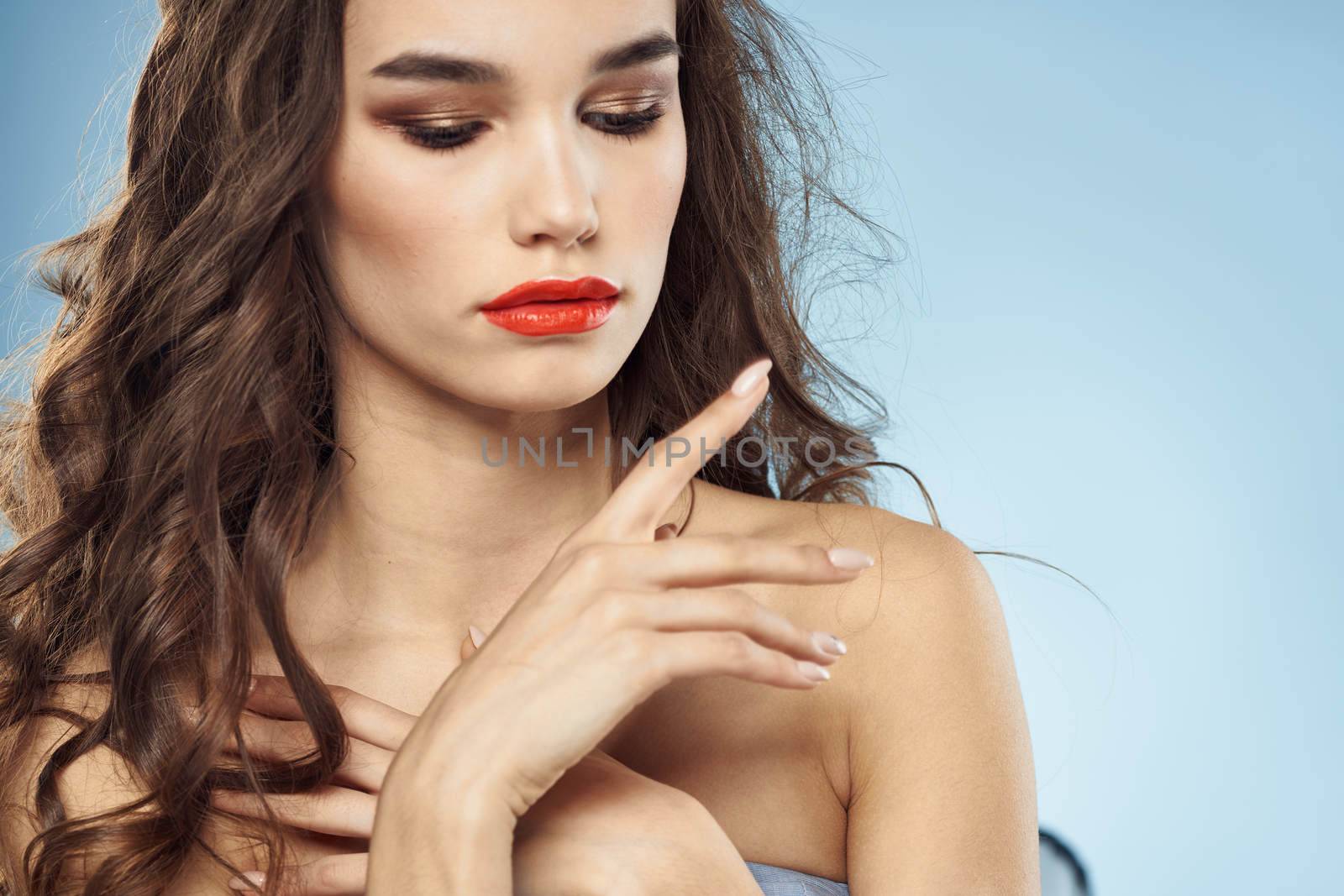 Brunette naked shoulders red lips fashionable hairstyle blue background by SHOTPRIME