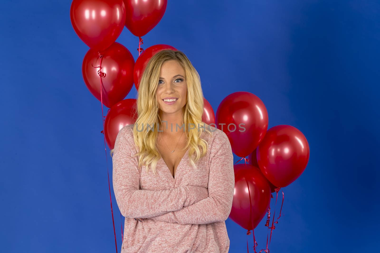 Lovely Blonde Model Posing Against Red Balloons In A Studio Environment by actionsports