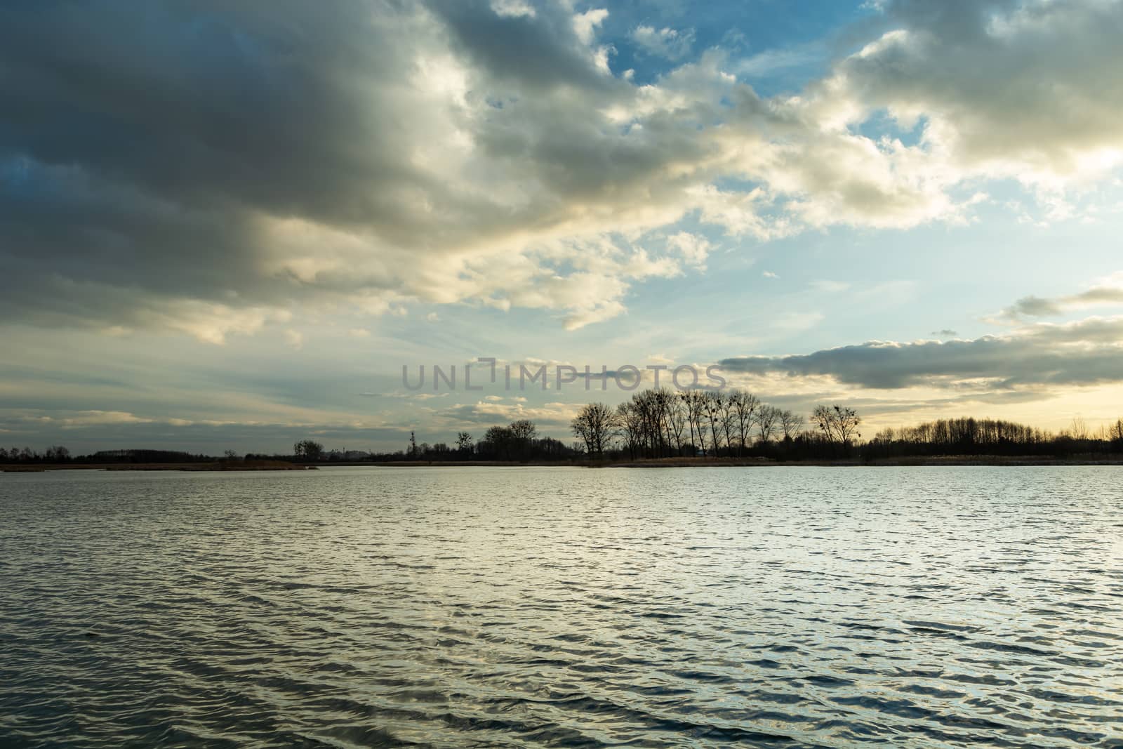 Evening clouds in the sky over a peaceful dark lake