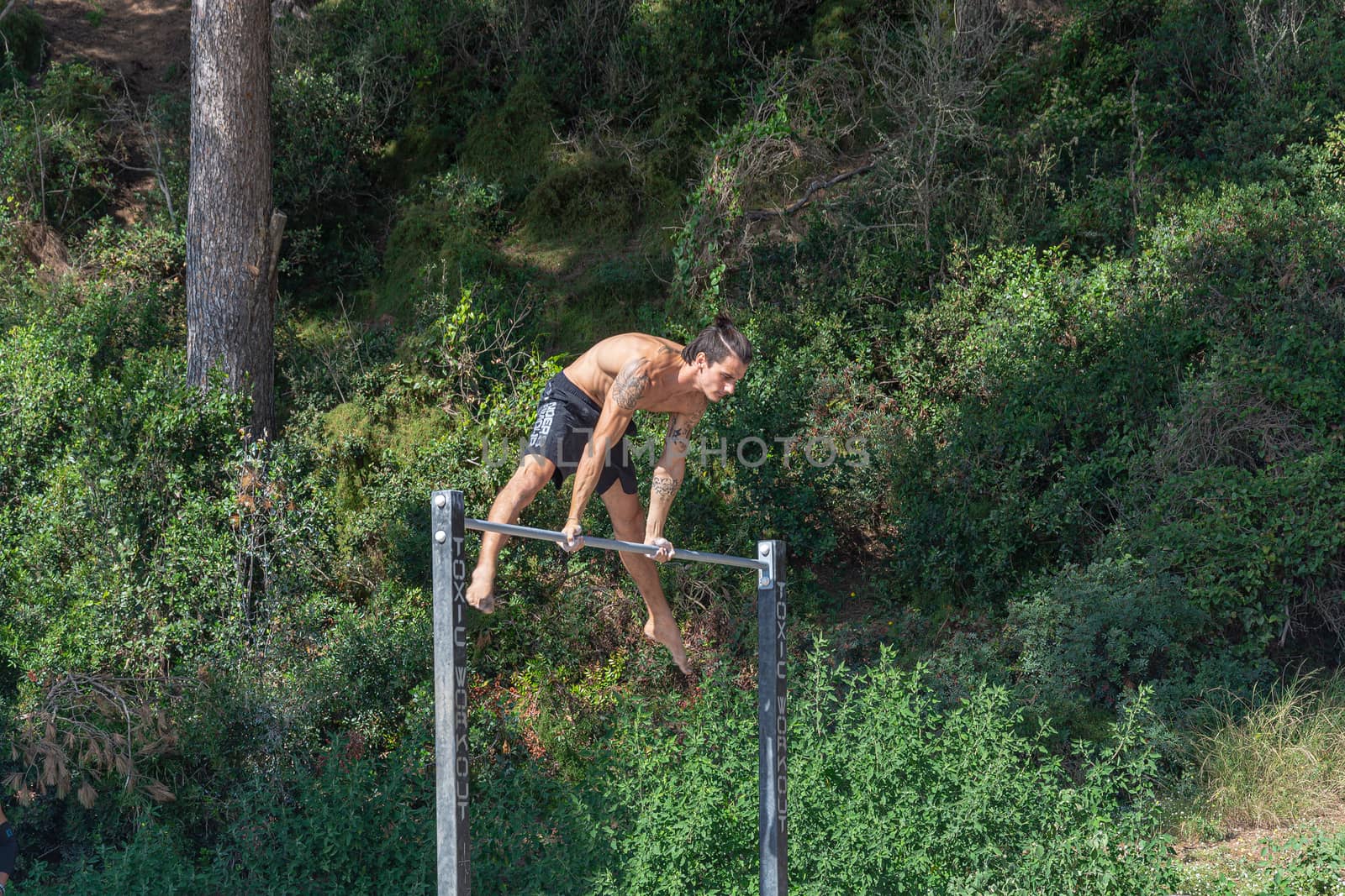 Spain, Tenerife - 09/15/2016: Young man exercising on a horizontal bar. Stock photography