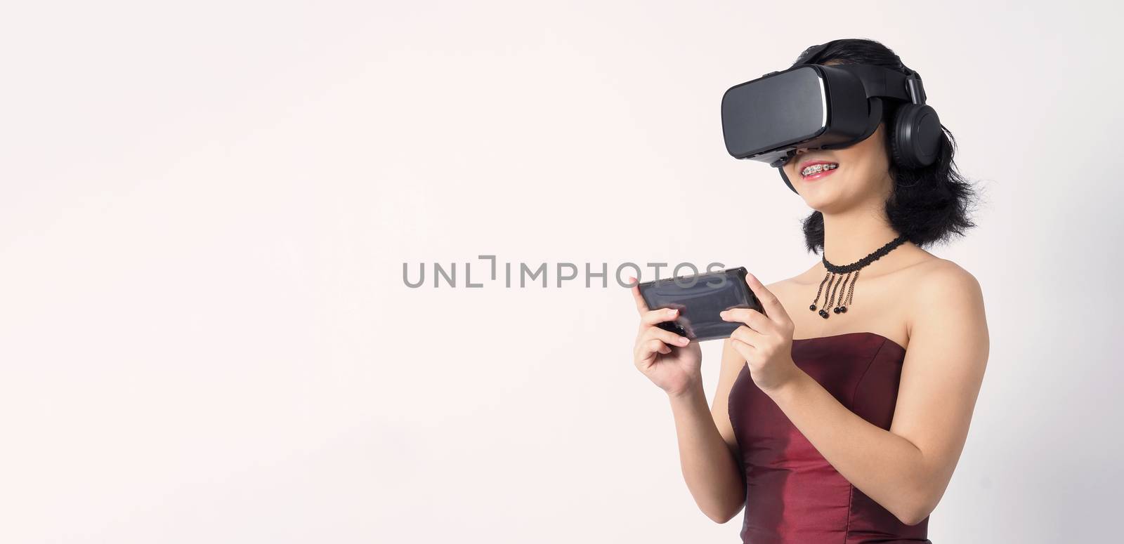 Asian teen woman wearing VR or Virtual Reality head set  by gnepphoto