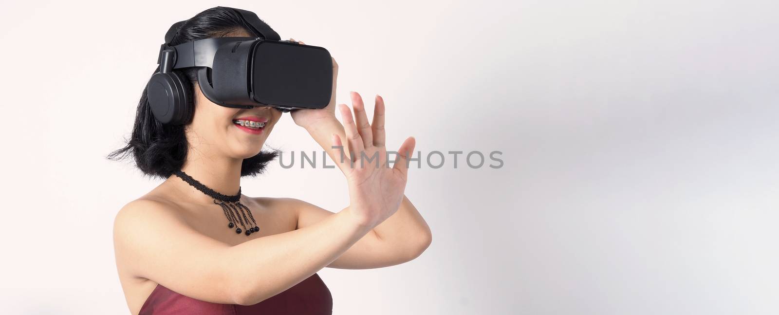 Asian teen woman wearing VR or Virtual Reality head set  by gnepphoto
