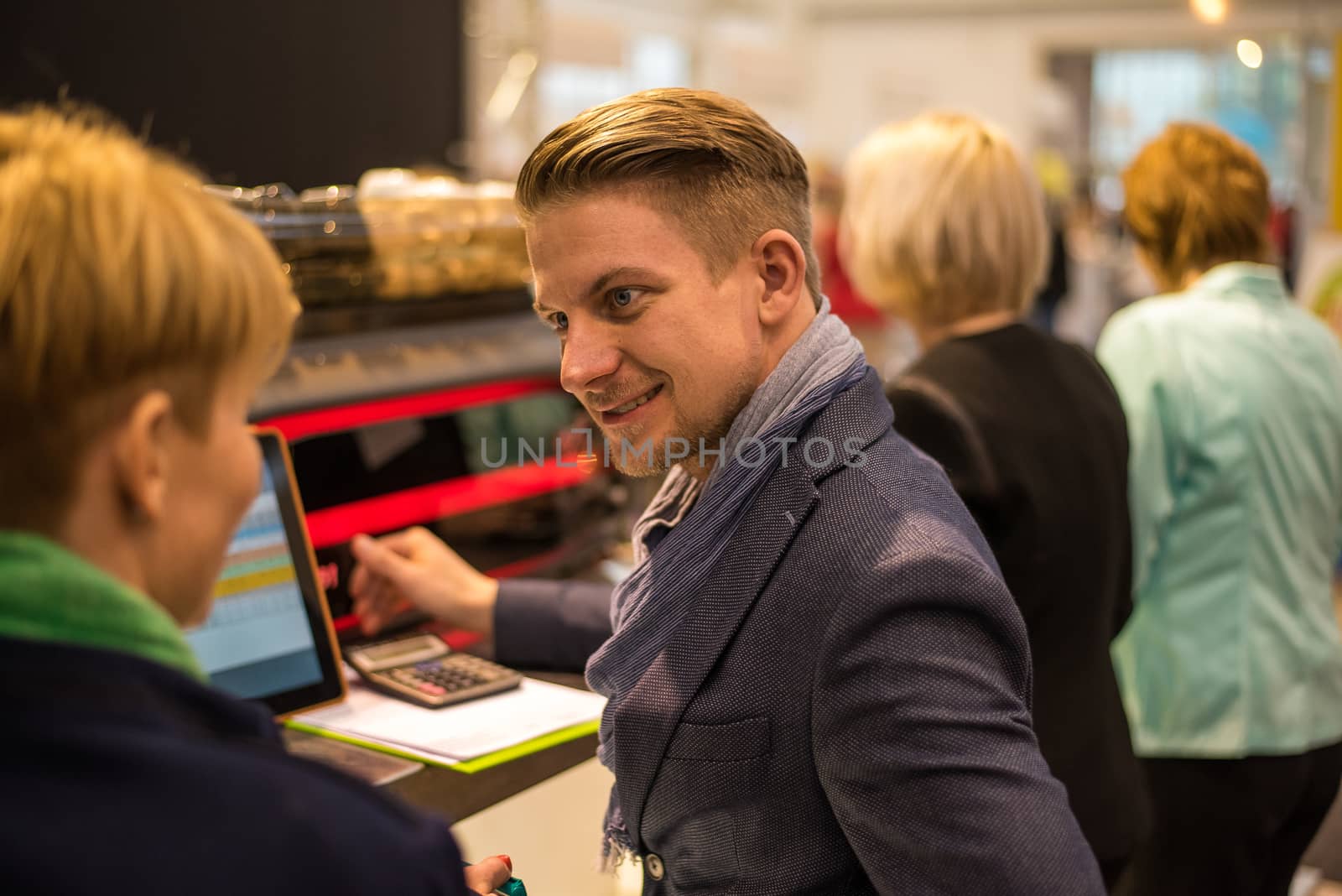 Sales person discussing a product he is offering to a potential client at a convention trade center. Brno Exhibition center. Czech Republic