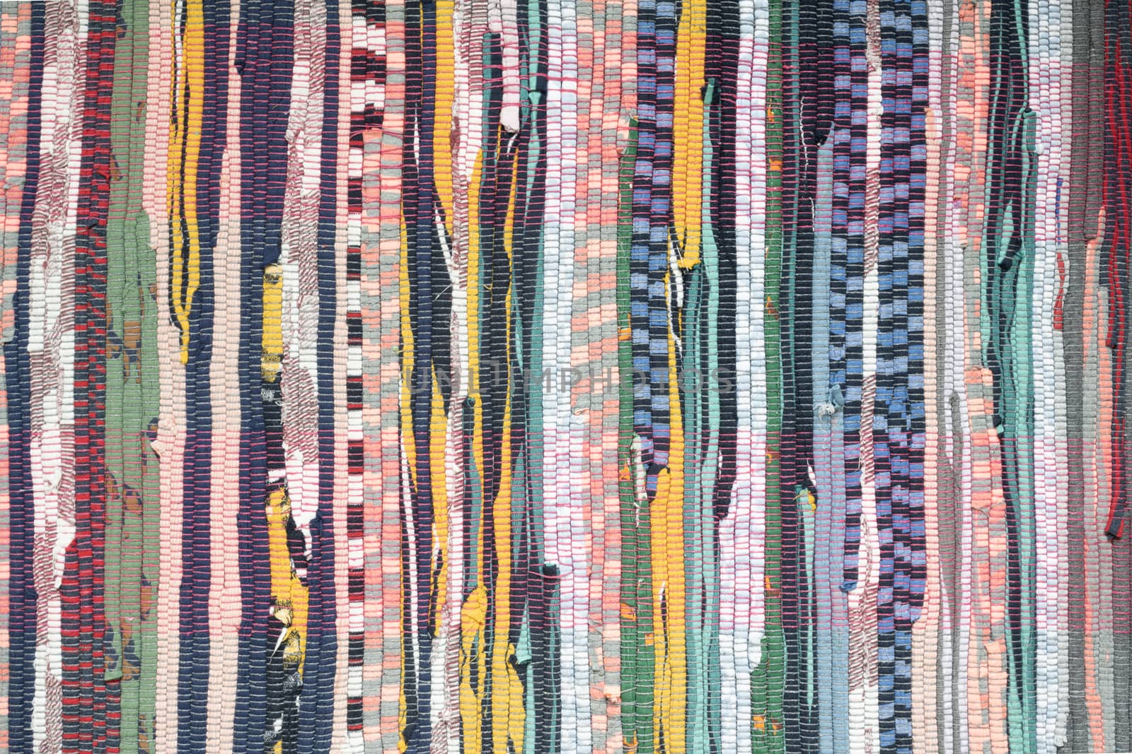 Fabric scraps, old clothing and textiles are cut into strips and grouped together, forming diagonal rows of disheveled pieces of cloth. Closeup design resembles an up-cycled blanket, rug or pillow. by sashokddt