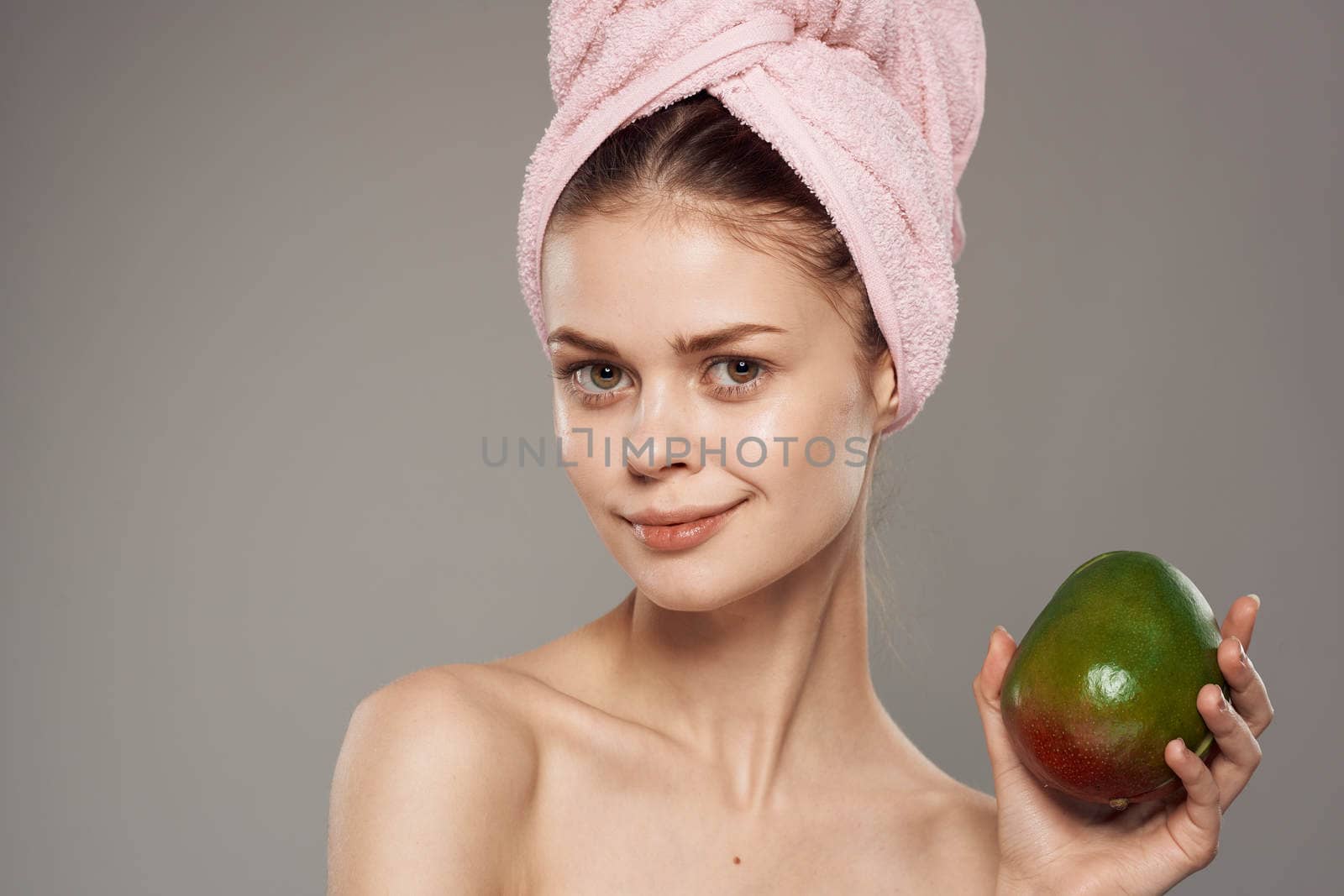 pretty woman pink towel on head cropped view of mango in hand lifestyle exotic. High quality photo