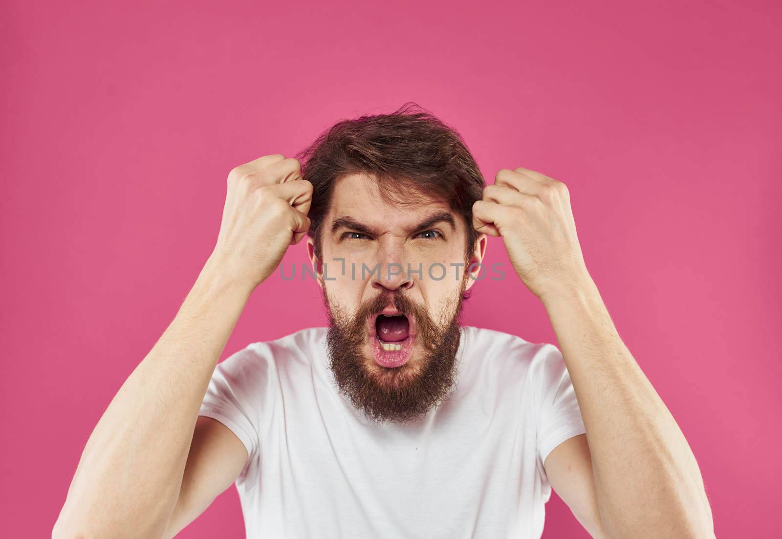 Man on a pink background surprise irritability emotions and stress. High quality photo