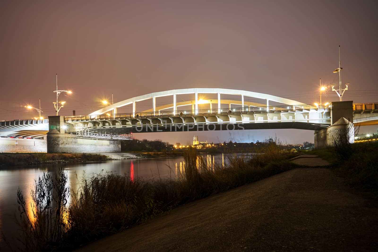 Steel structure of road bridge over the Warta river at night in the city of Poznan