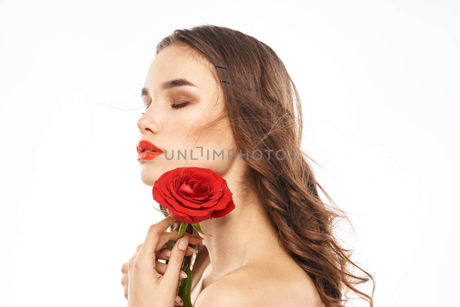 Woman with naked shoulders and red rose evening makeup light background. High quality photo