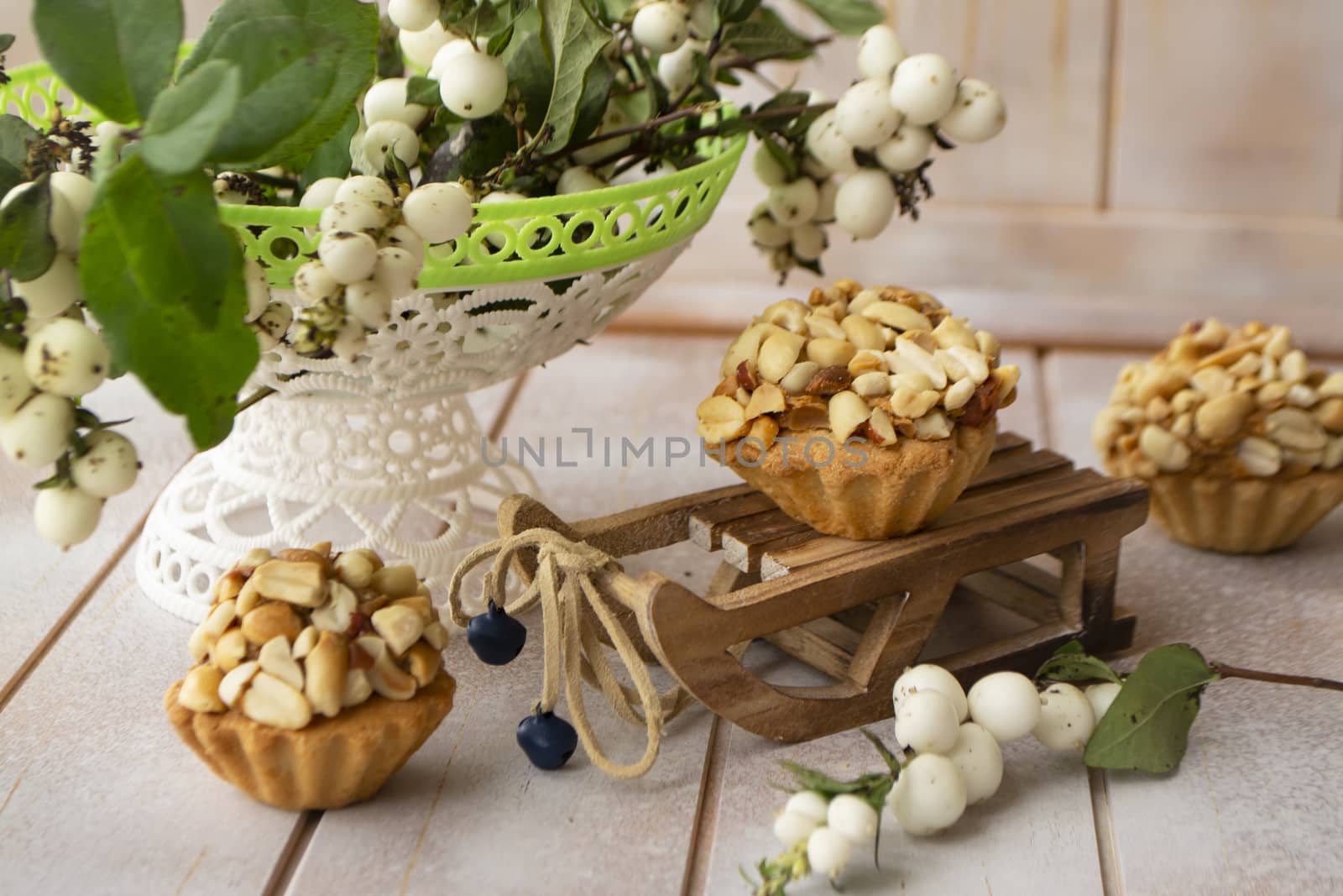 Homemade peanut muffins with white berries on decoration on shabby wooden table