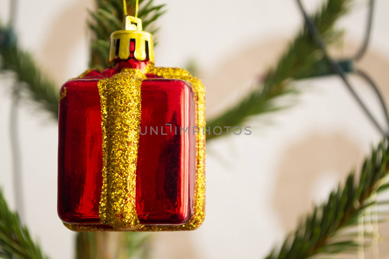 Close up red New Year's gift box toy on the branches of a Christmas tree. The concept of Christmas gifts