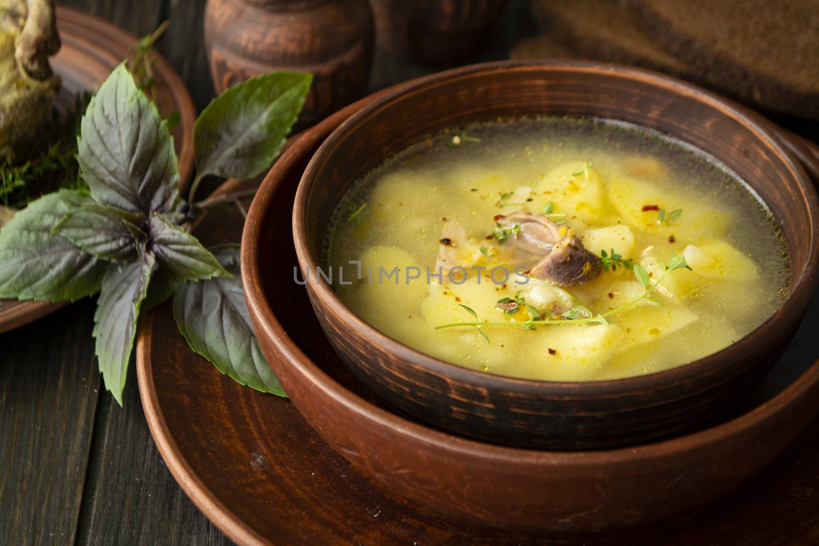 Horseradish soup with wild partridge in a brown vintage bowl. Russian cuisine