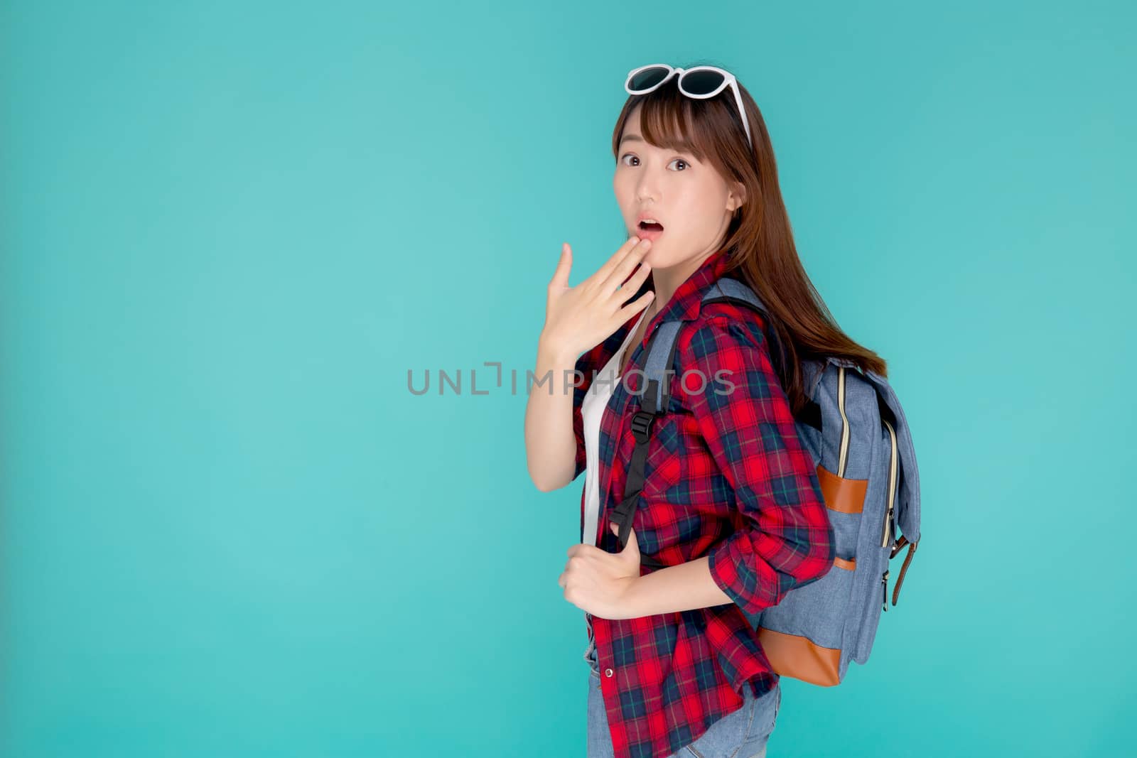 Beautiful portrait young asian woman surprise wearing travel summer fashion with tourist in vacation isolated on blue background, girl shocked expression and emotion, holiday amazing concept.