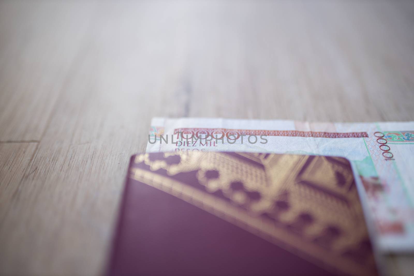 Picture of a Blurry Swedish Passport with half a 10.000 Colombian Pesos Bill Inside