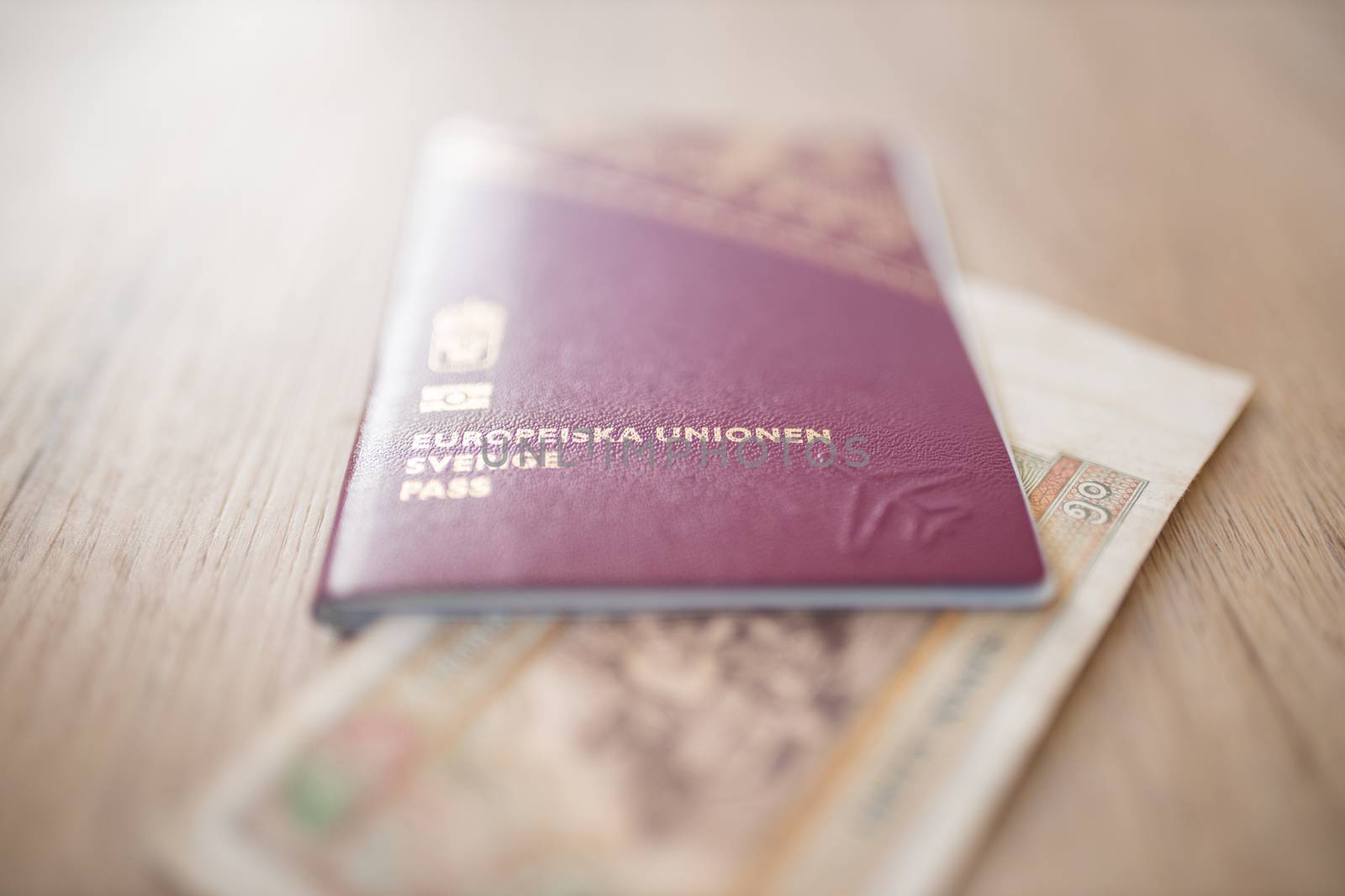 Picture of a Swedish Passport that reads: European Union Sweden Passport, and has a Fifty Burmese Kyats Bill with the number 50 in Burmese