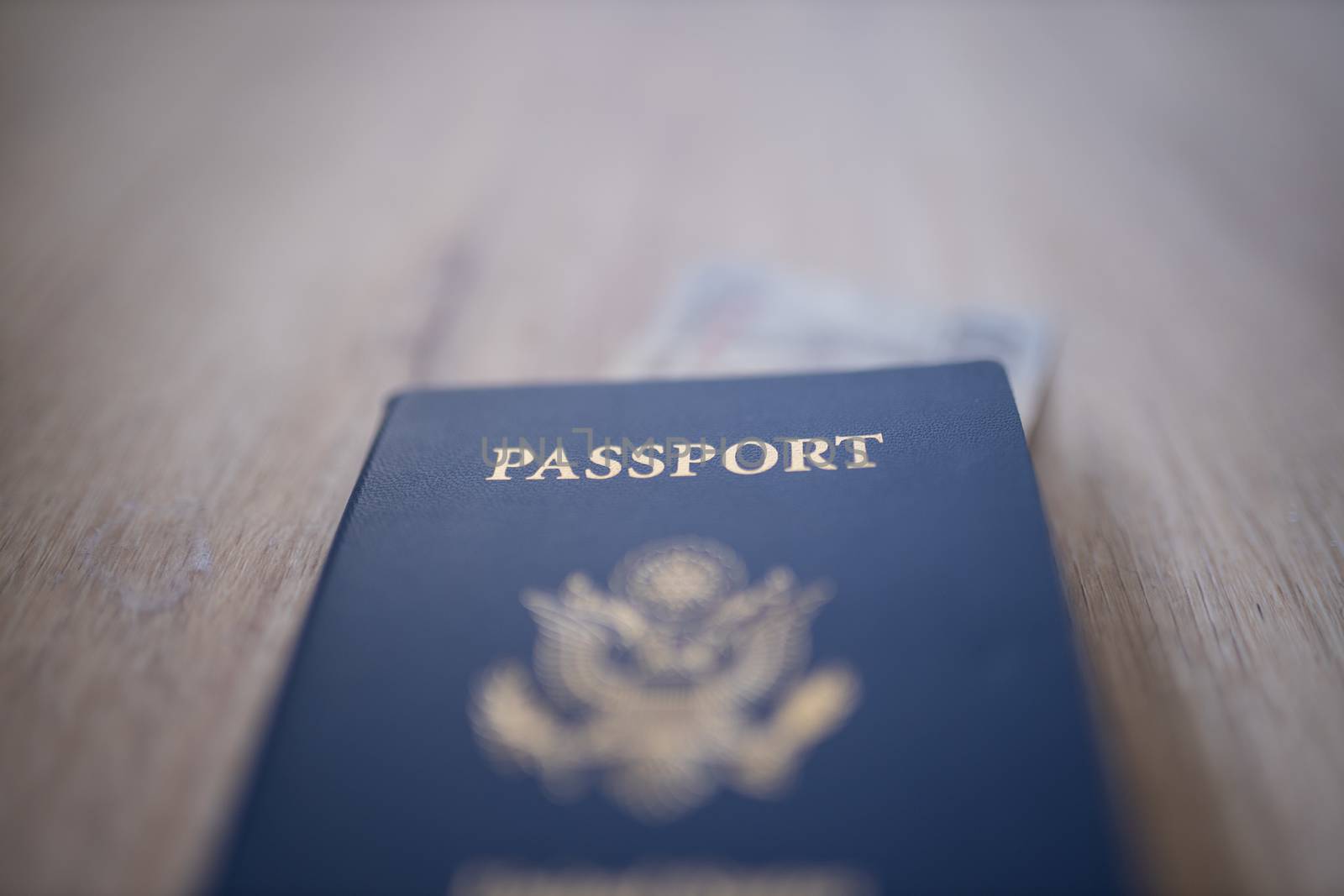 Picture of a blurry United States of America Passport with a blurry 100 Moroccan Dirhams Bill Partially Inside