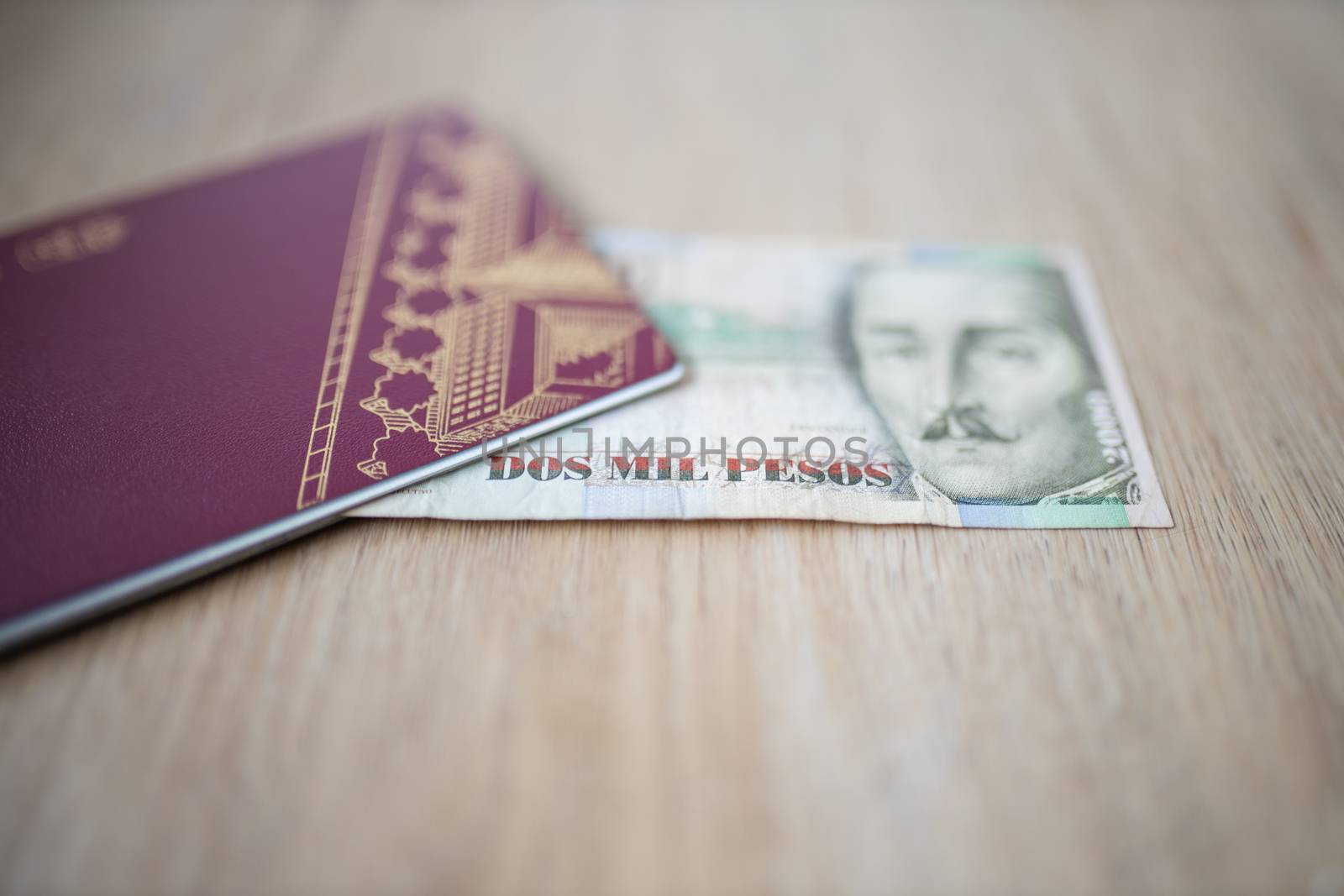 Picture of a Two Thousand Colombian Pesos Bill Partially Inside a Sweden Passport, showing the face of Francisco de Paula Santander