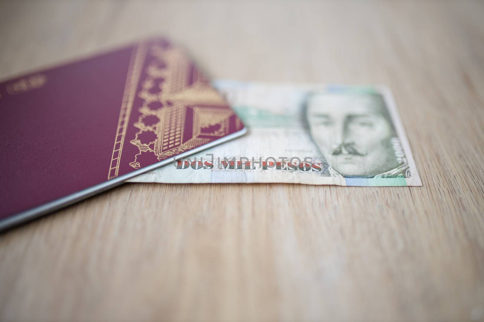 Picture of a Two Thousand Colombian Pesos Bill Partially Inside a Sweden Passport, showing the face of Francisco de Paula Santander