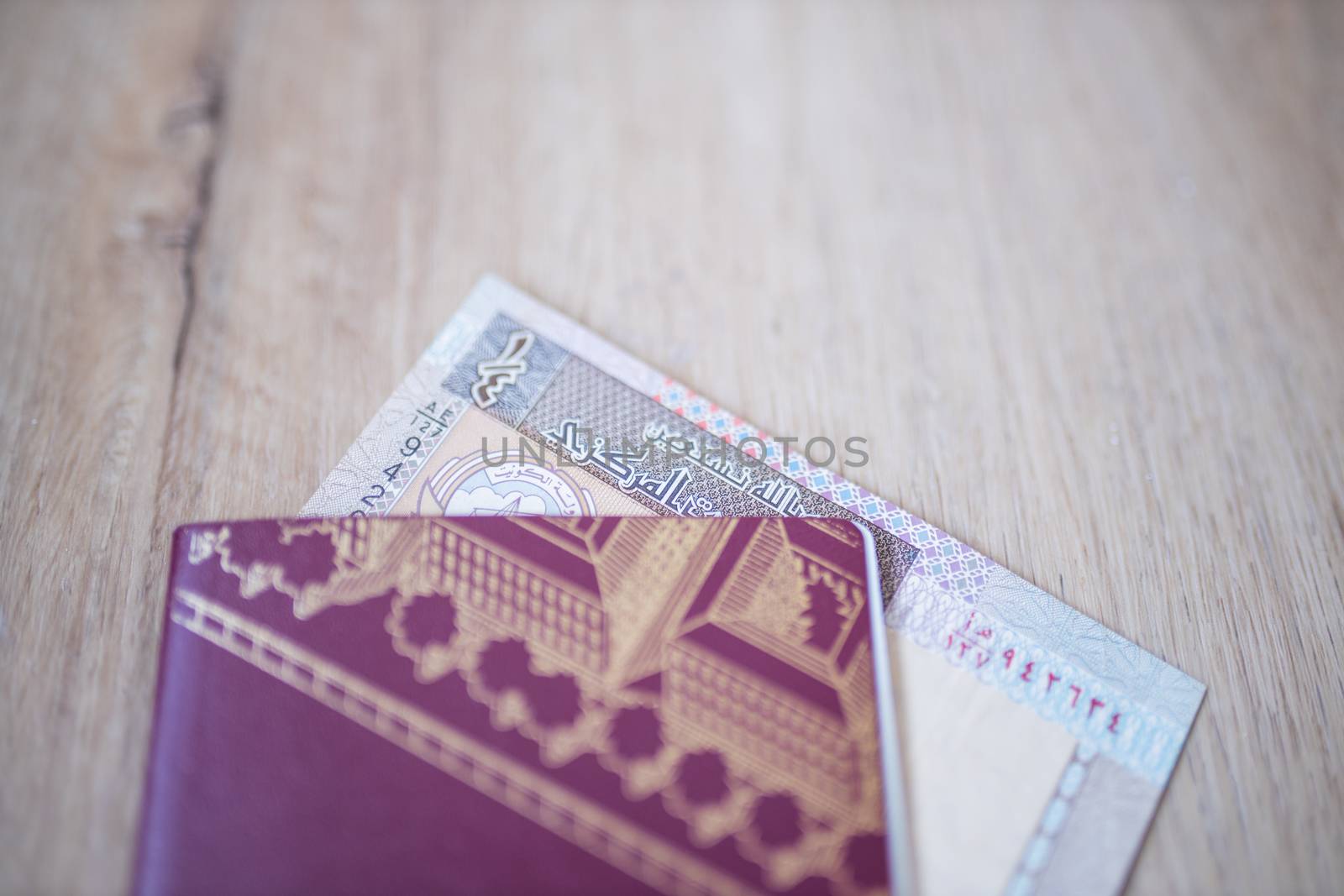 Picture of a Kuwait Quarter Dinar -with the words Bank of Kuwait and the numbers 1-fourth in Arabic- Partially Inside a Sweden Passport
