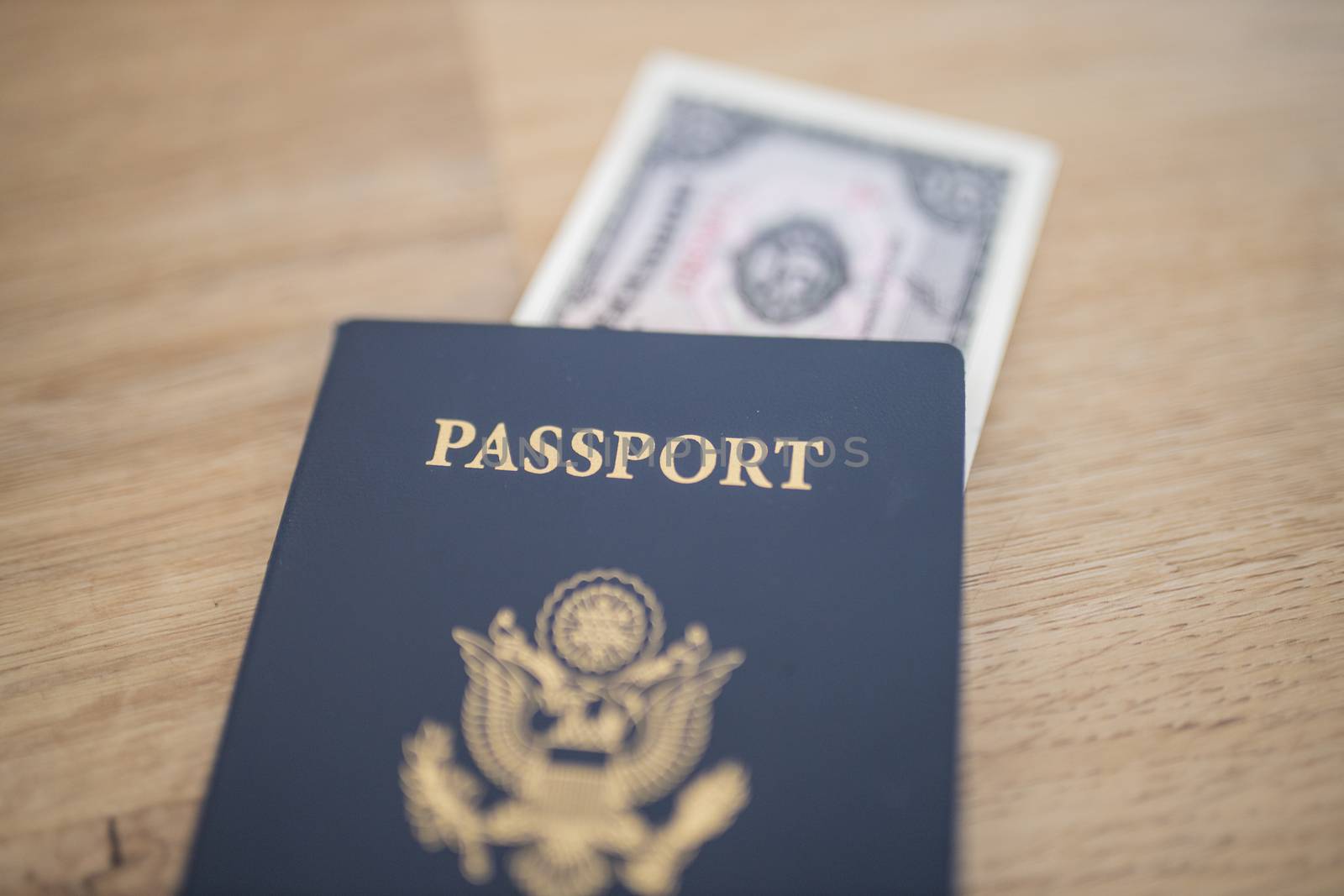 Picture of a United States of America Passport with a blurry Five Ecuadorian Sucres Bill partially Inside