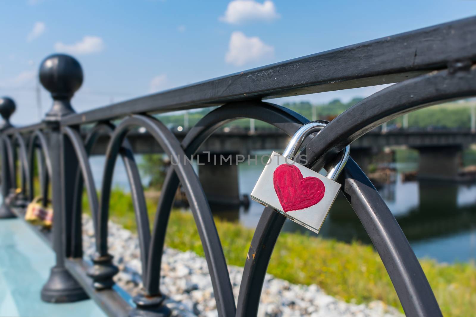 Padlock weighs on the railing of the pavement, hung on Valentine's Day
