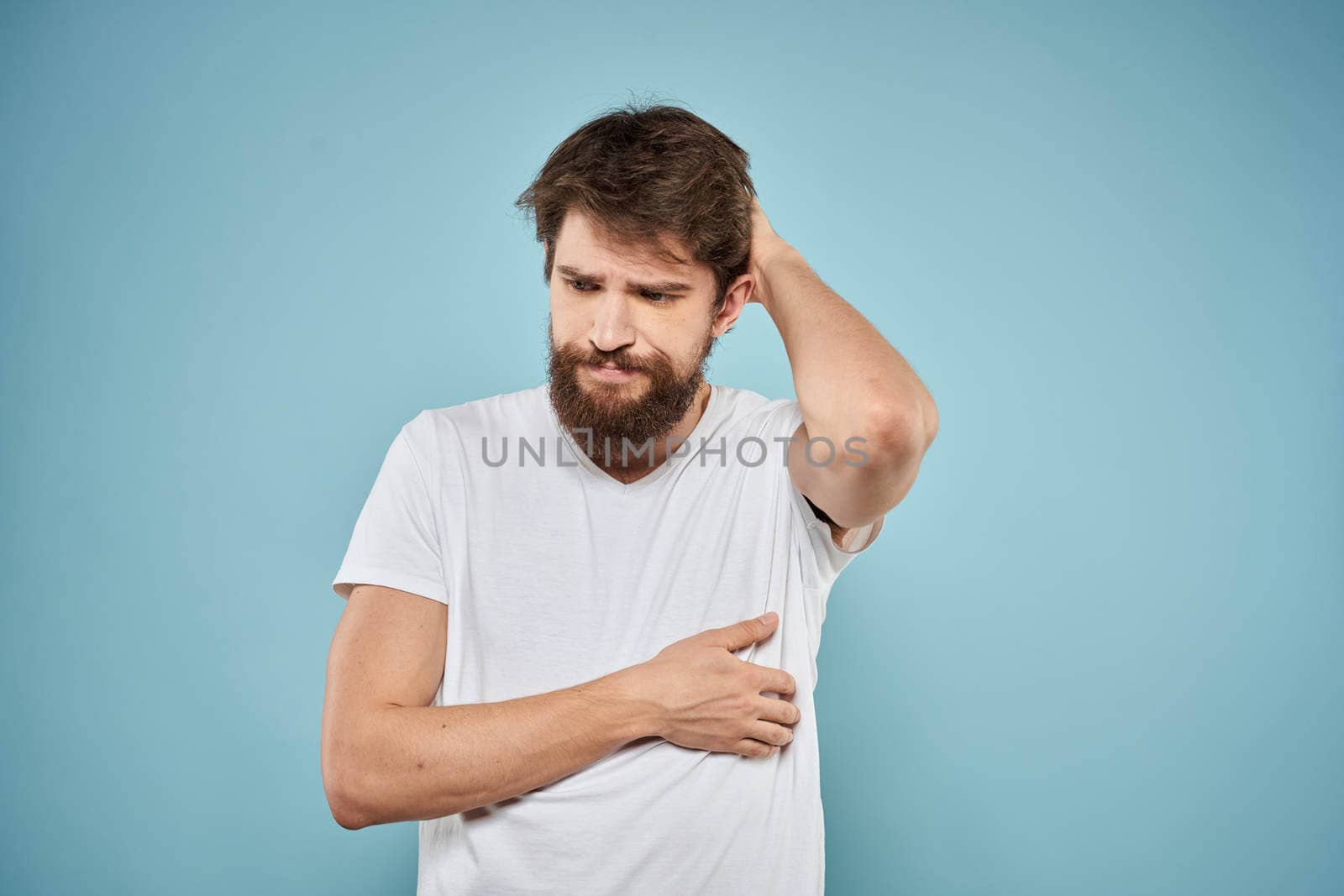 Man in white t-shirt lifestyle studio emotions facial expression blue isolated background by SHOTPRIME