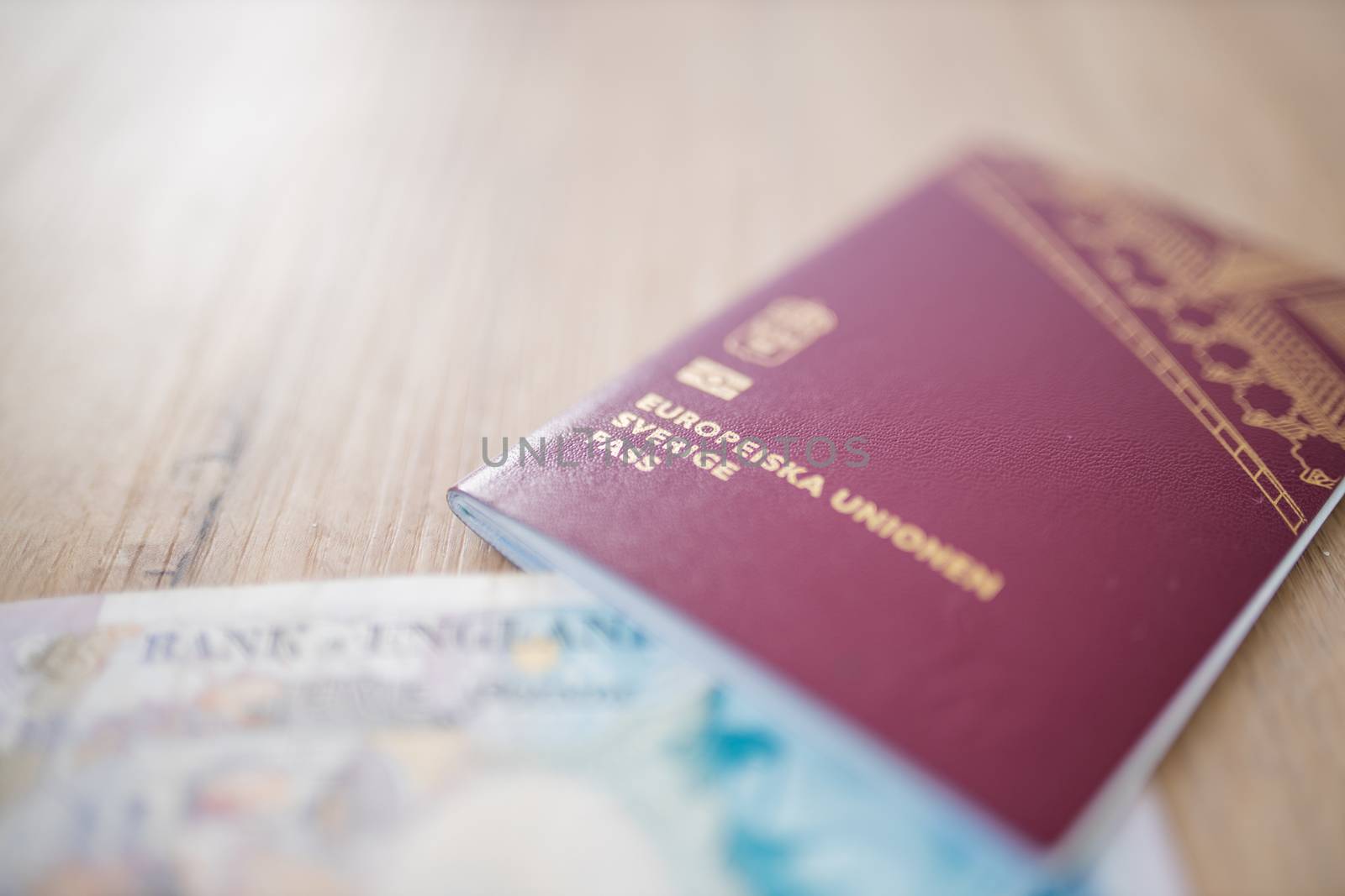 Picture of an European Union Sweden Passport with the corner of a Five Pound Note inside