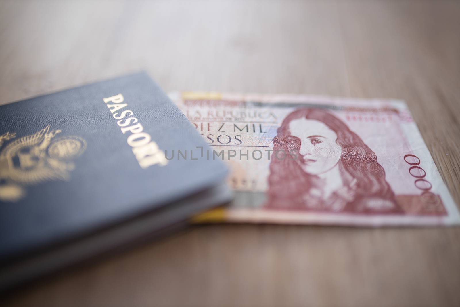 United States of America Passport with half a 10.000 Colombian Pesos Bill Inside, showing the Face of Policarpa Salavarrieta