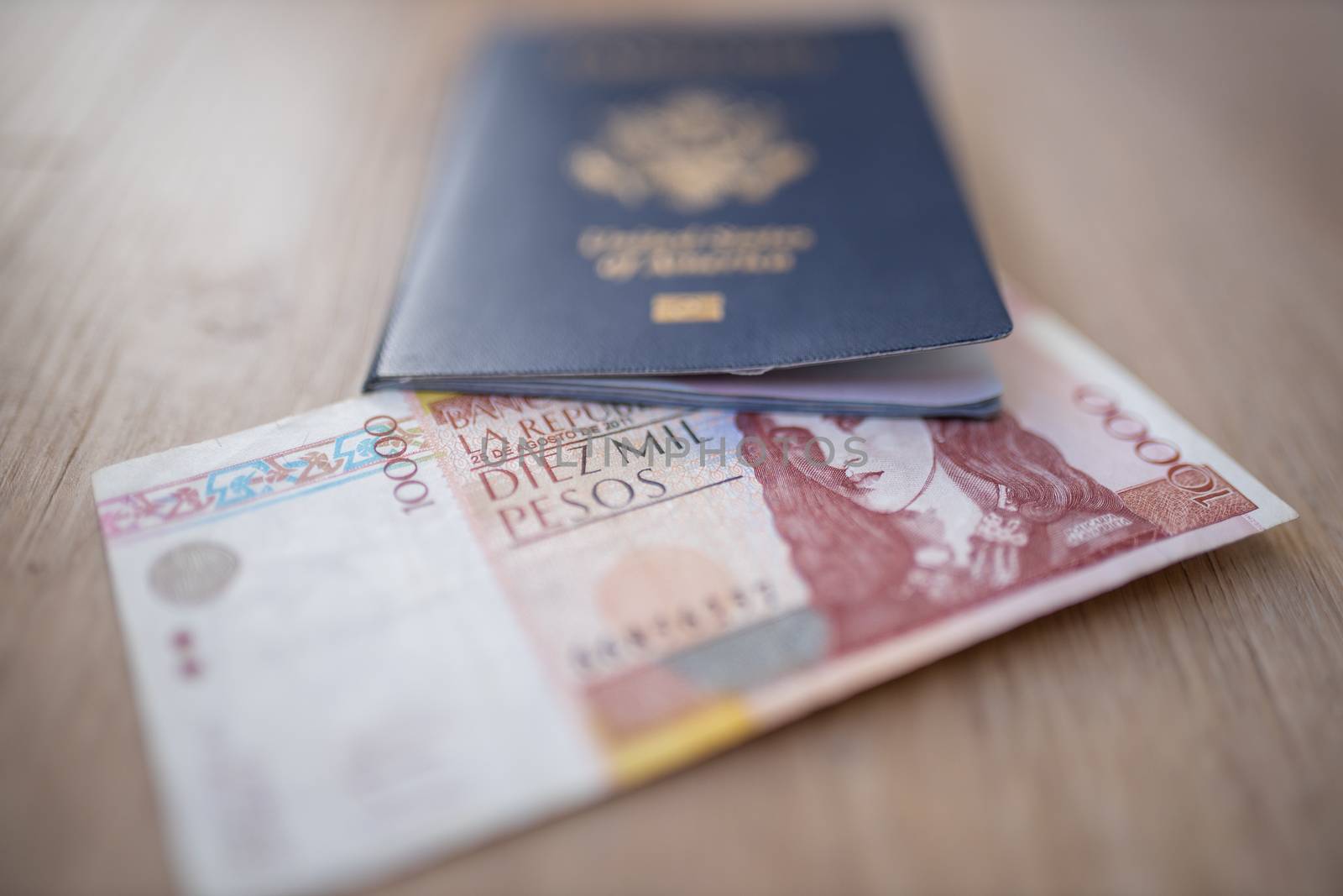 United States of America Passport with half a 10.000 Colombian Pesos Bill Inside, showing the Face of Policarpa Salavarrieta