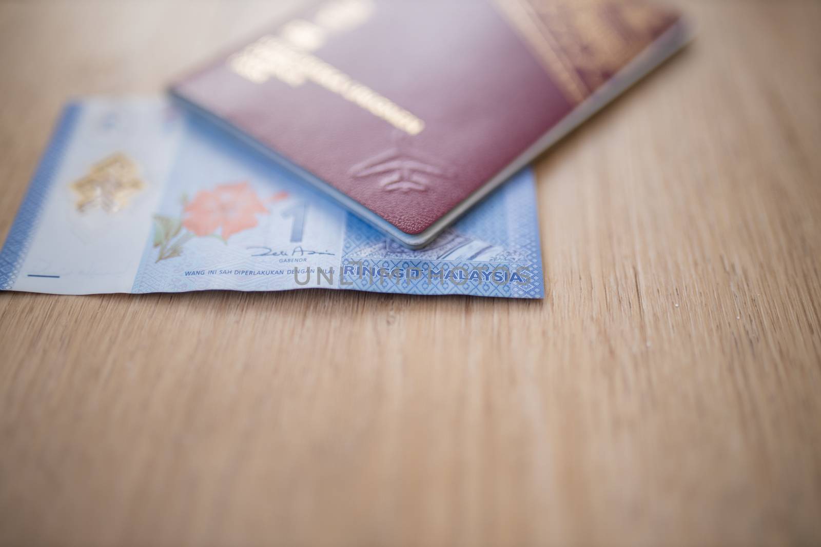Picture of a Sweden Passport covering part of a blurry One Malaysian Ringgit Note