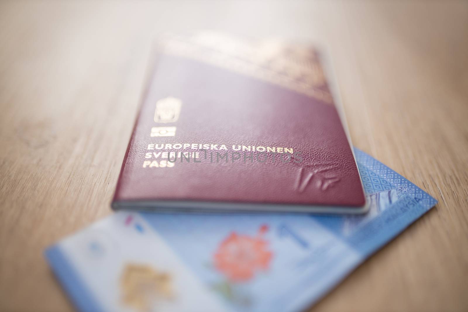 Picture of an European Union Sweden Passport covering part of a blurry One Malaysian Ringgit Note